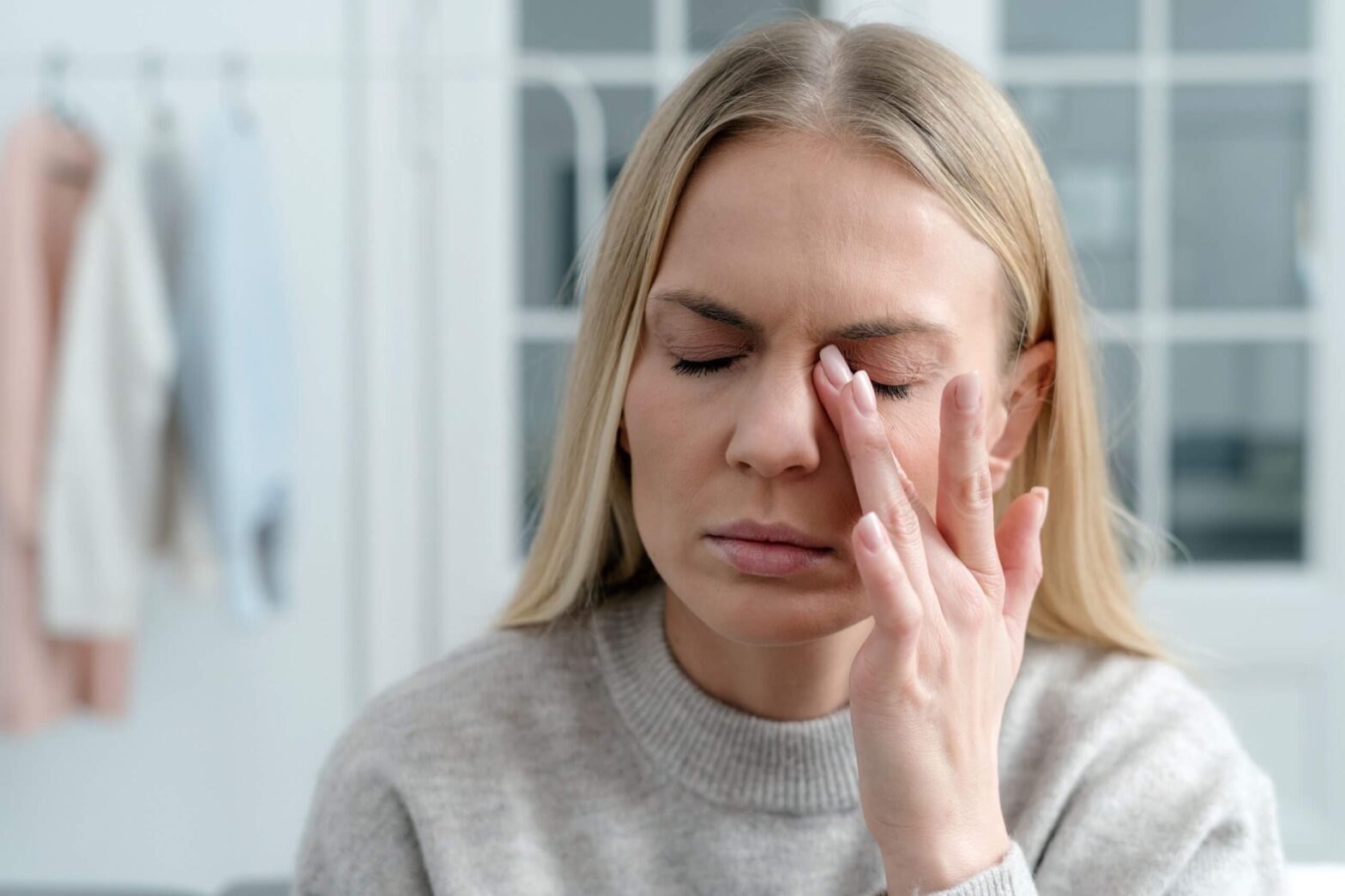 A woman rubbing her dry eyes due to cold weather in the winter